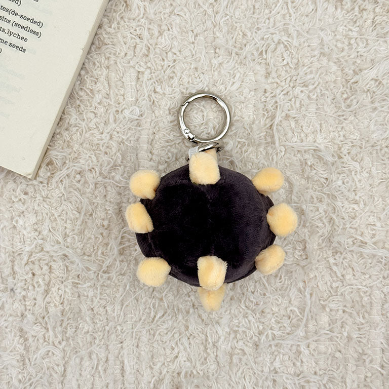 Soft microbe plush keychain with adorable embroidered face and fluffy virus shape.