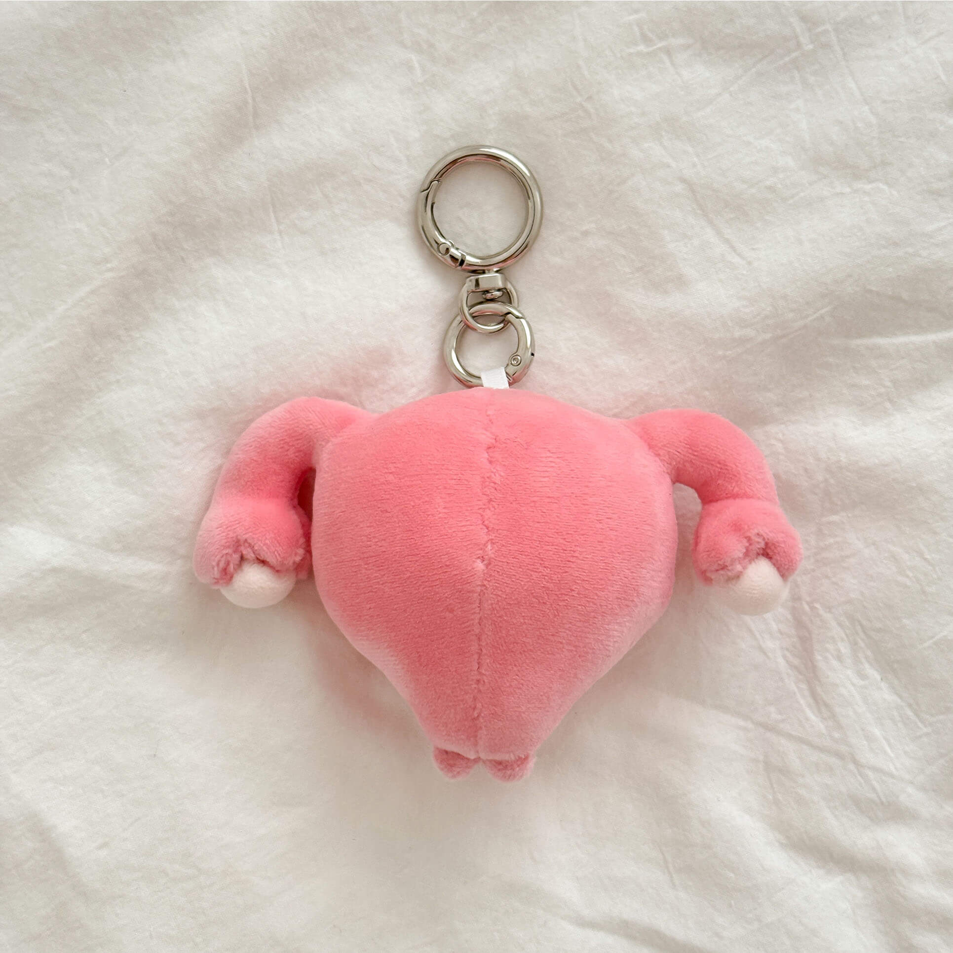 Adorable anatomy uterus plush keychain with soft fabric, cute face, and silver keychain hardware.