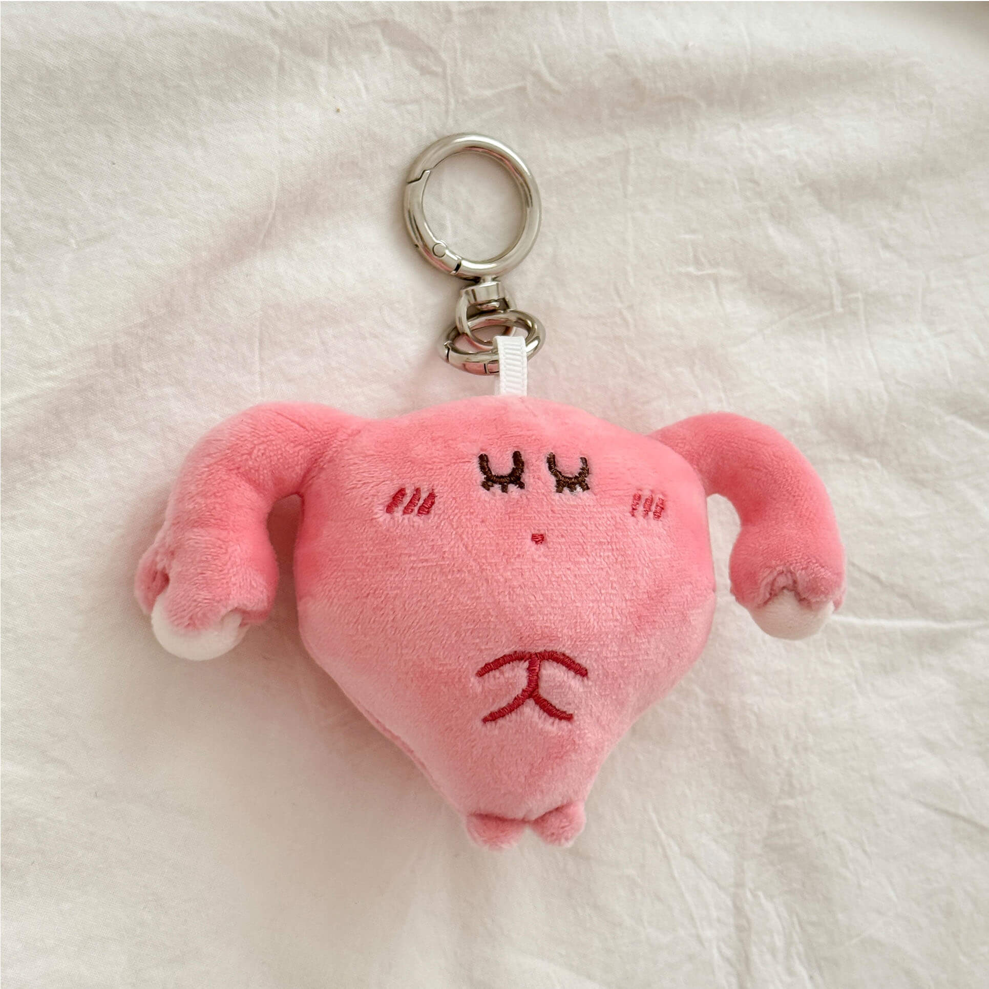 Uterus organ stuffed keychain with fluffy plush texture and secure metal ring attachment.