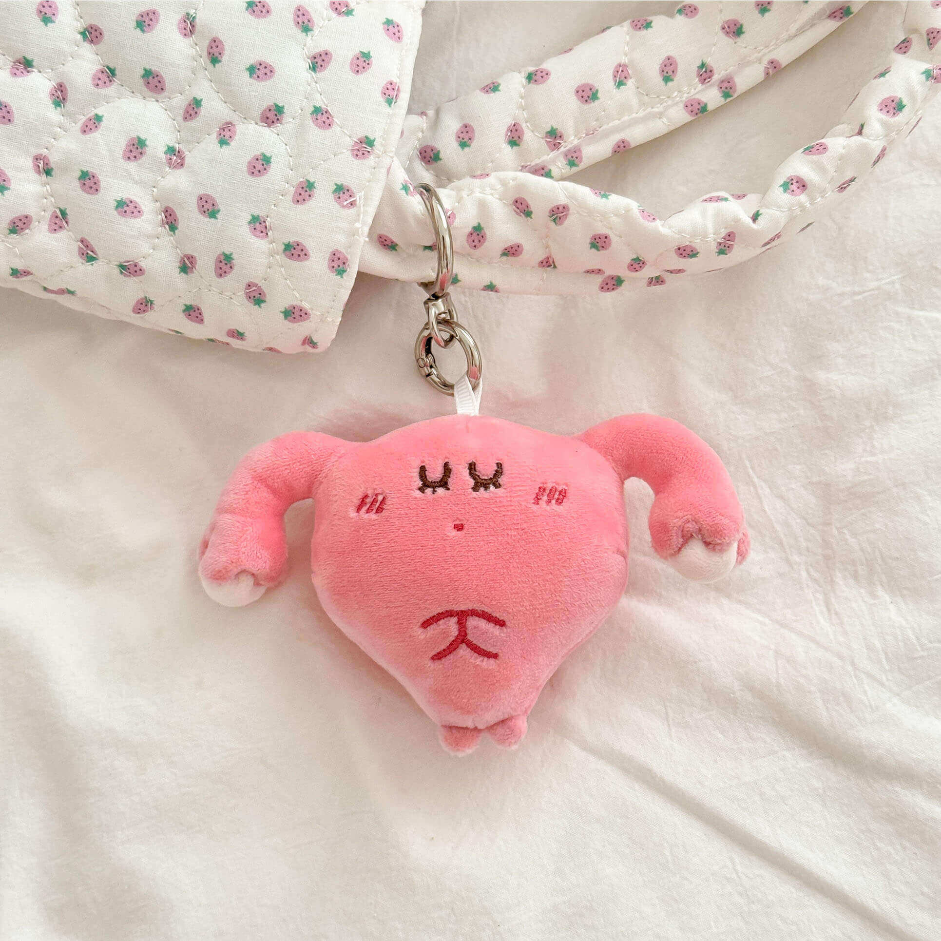 Cute plush uterus keychain inspired by human anatomy with soft pink finish and metal key ring.