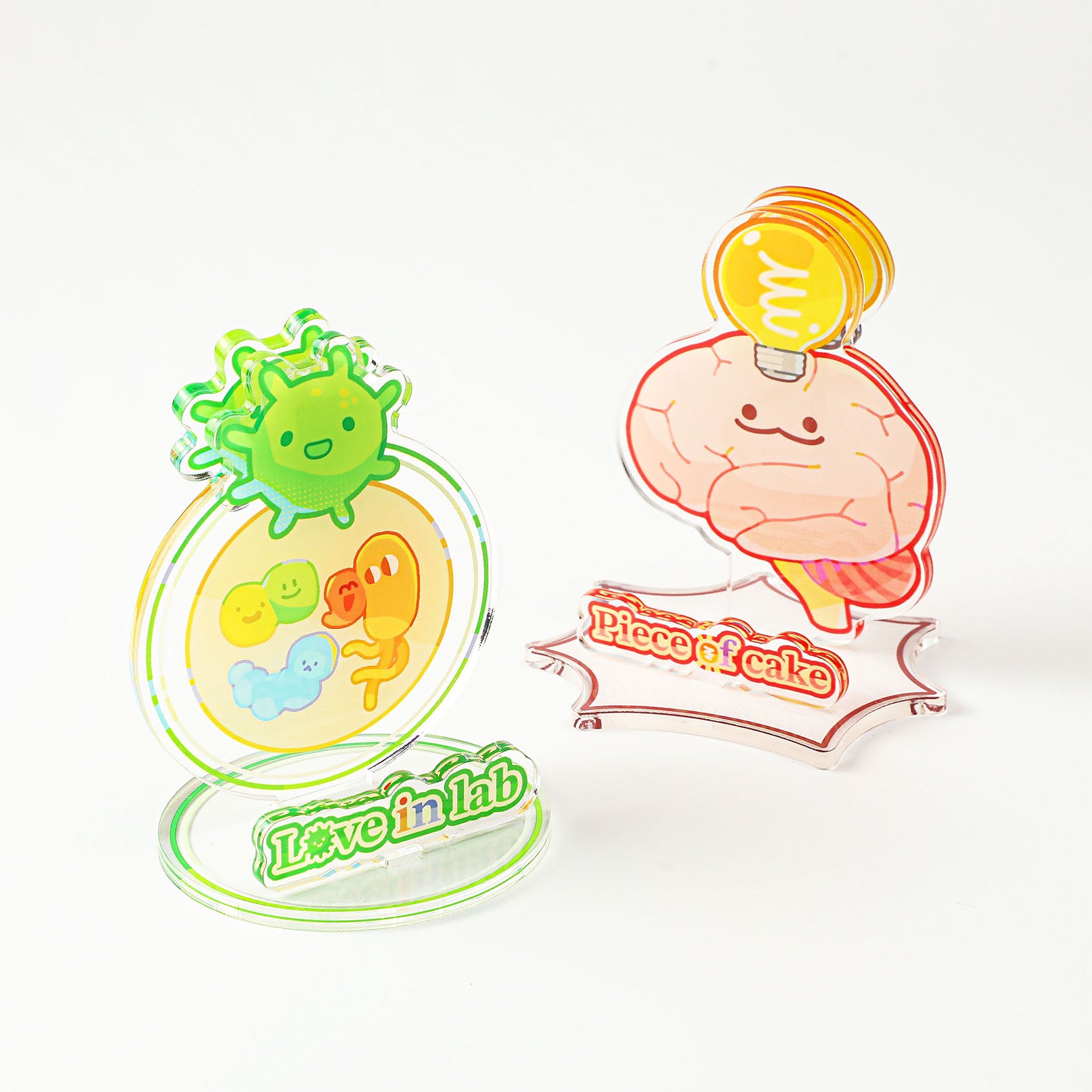 Cute laboratory-themed acrylic display featuring smiling microorganism and brain designs, adding a playful scientific touch to any workspace.