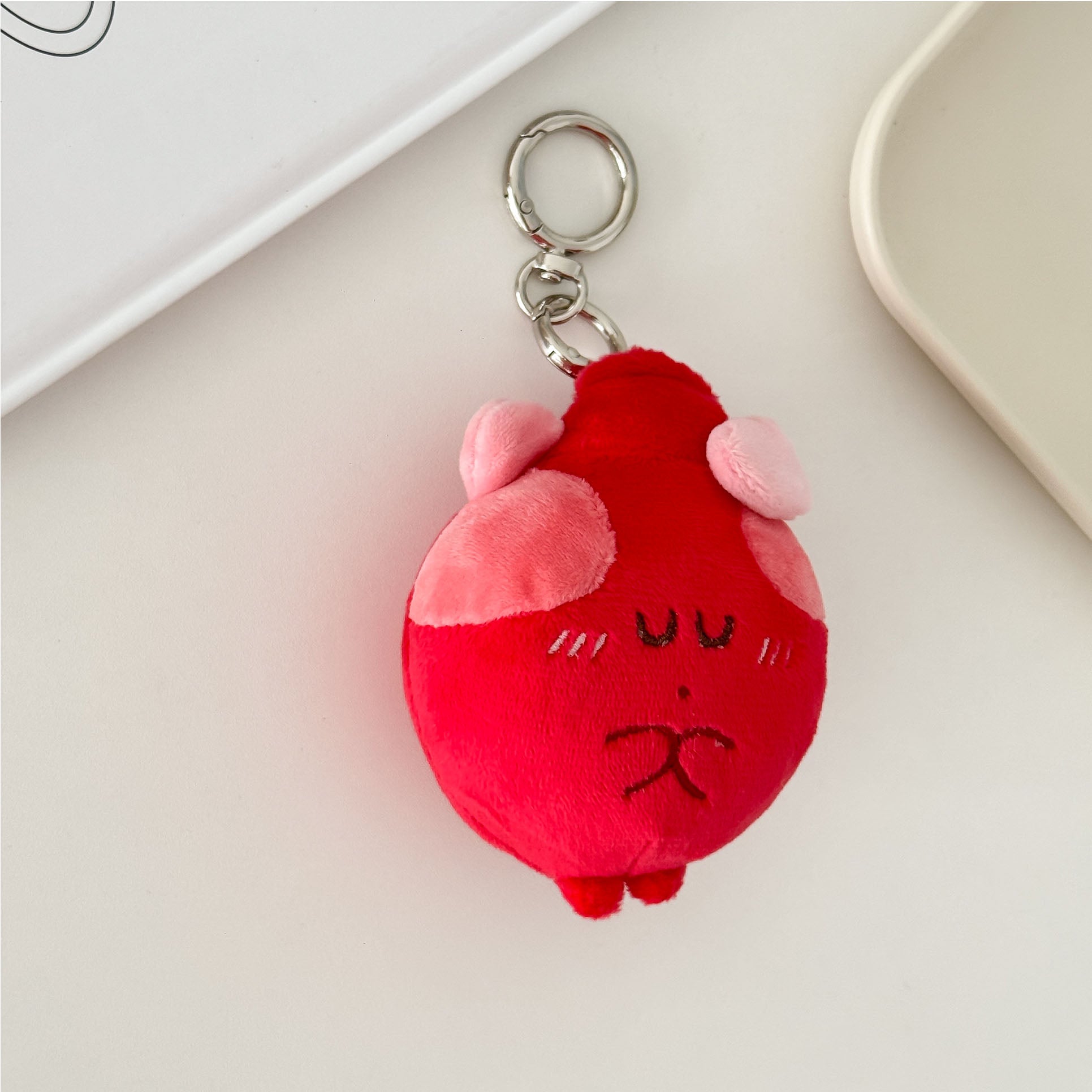 Red heart plush keychain with adorable cartoon expression and silver metal key ring.