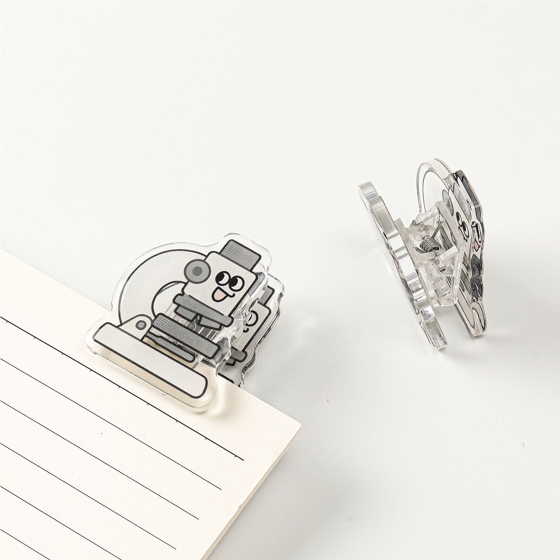 Science microscope acrylic clip featuring a transparent finish, ideal as a decorative office accessory for students, teachers, and laboratory enthusiasts.