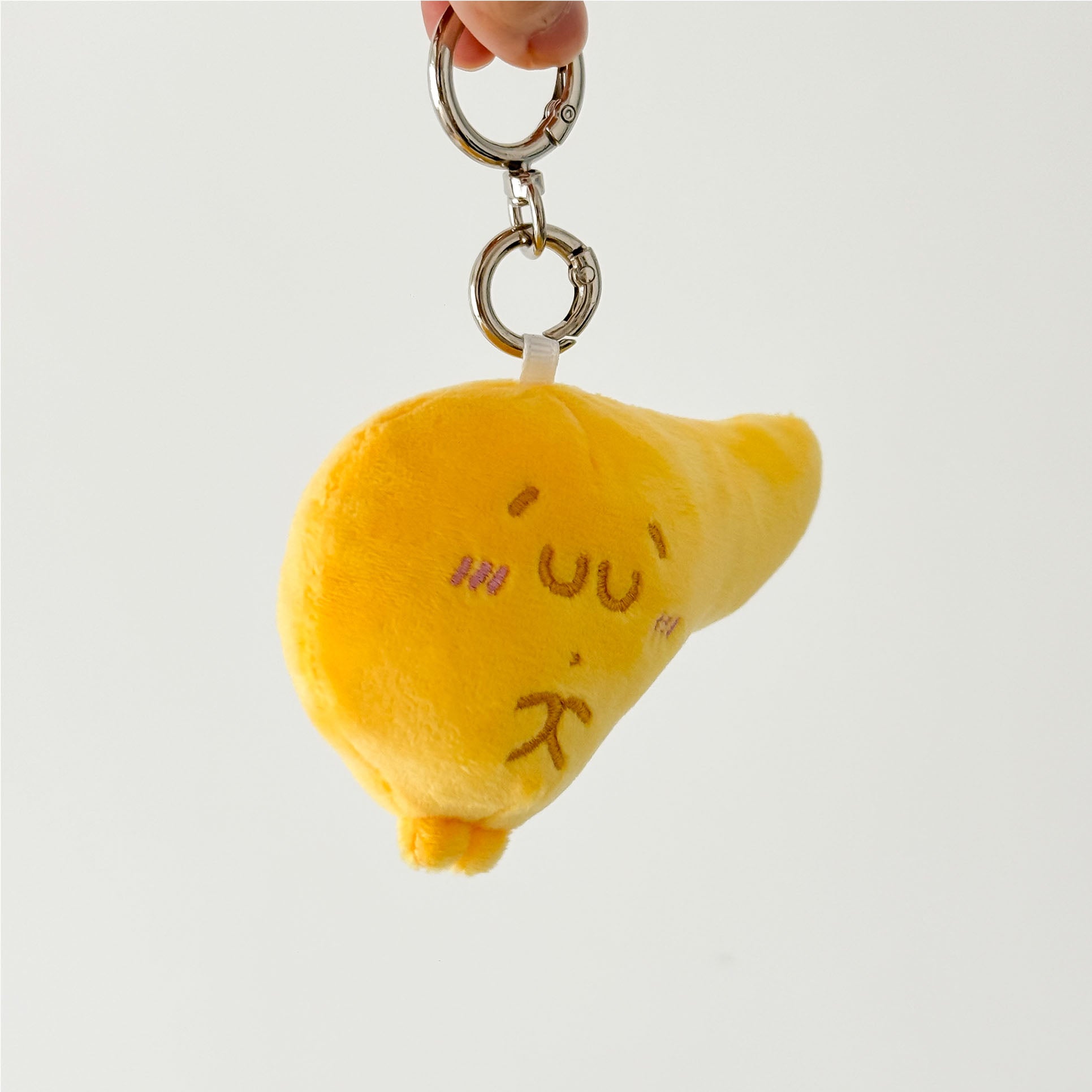 Yellow pancreas plush keychain with adorable cartoon expression and silver metal key ring.