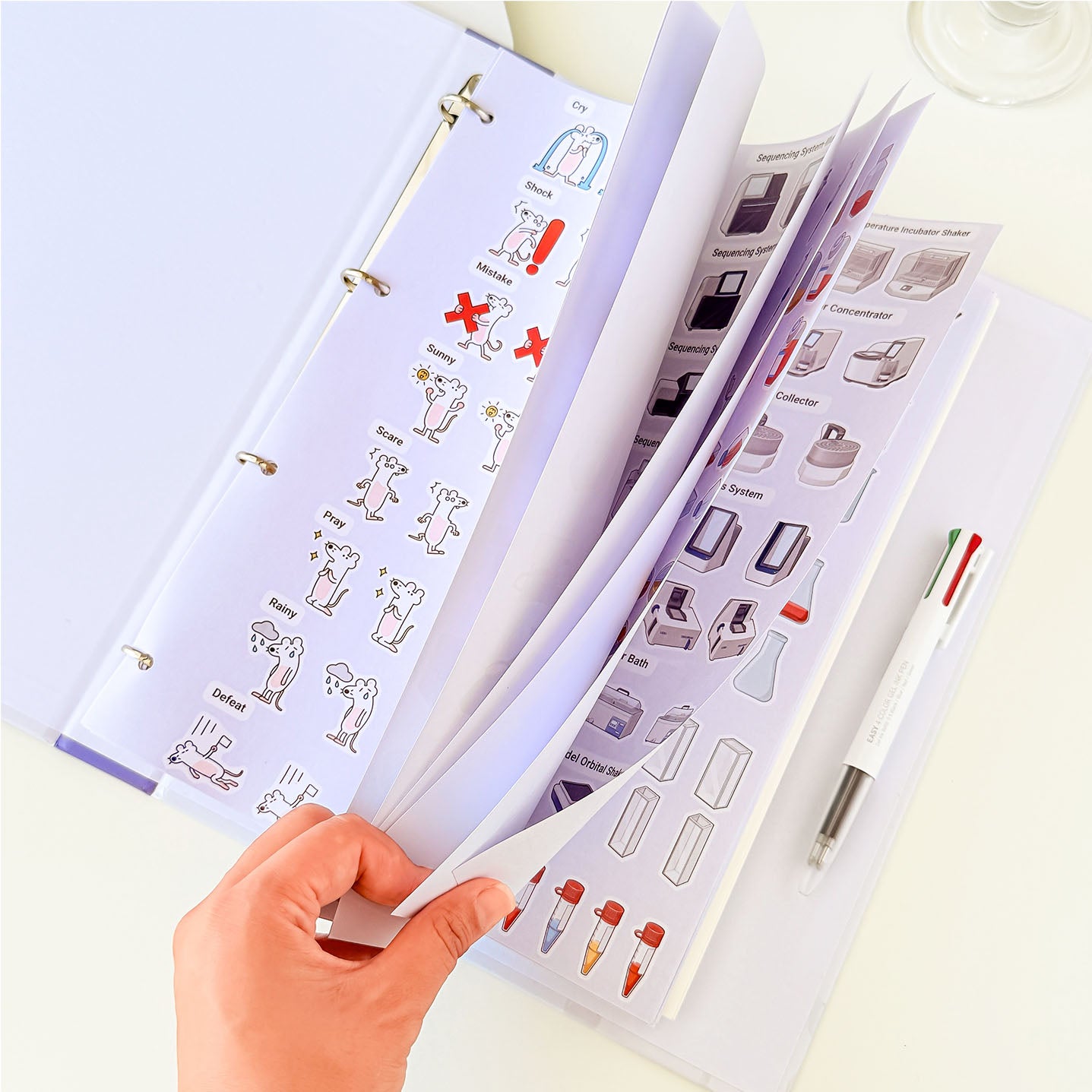 Educational laboratory notebook featuring colorful scientific illustrations of laboratory tools and cell culture materials.