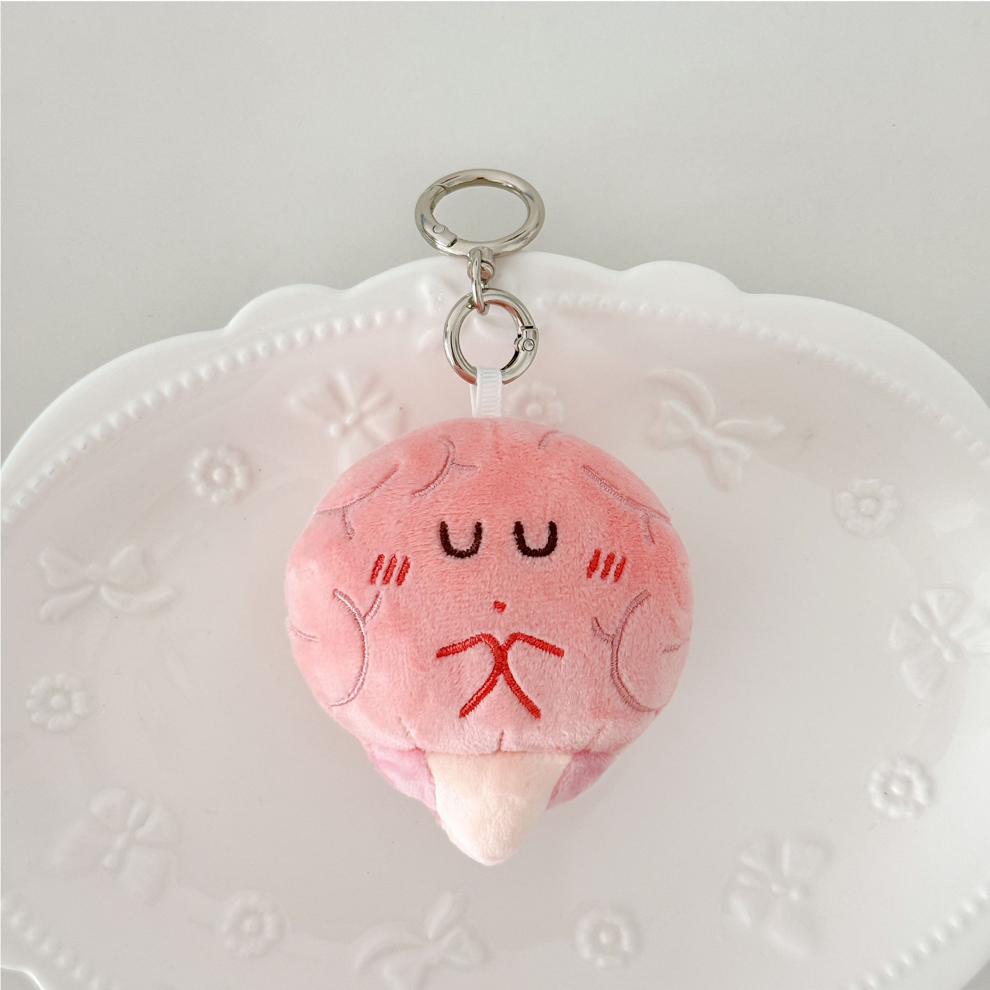 Cartoon brain plush keychain in pastel pink with embroidered details and premium key ring.